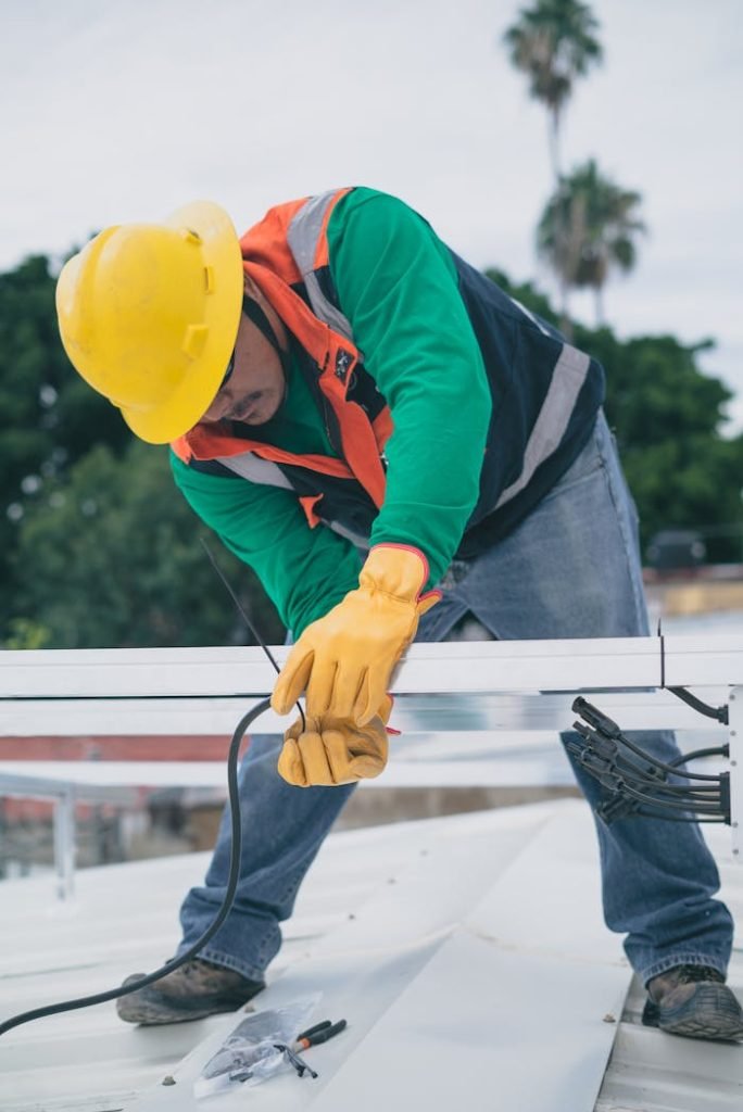 Mastering the First Impression: Your intriguing post title goes here A construction worker wearing PPE installs electrical equipment on a roof.